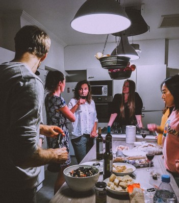 men and women standing infront of dining table